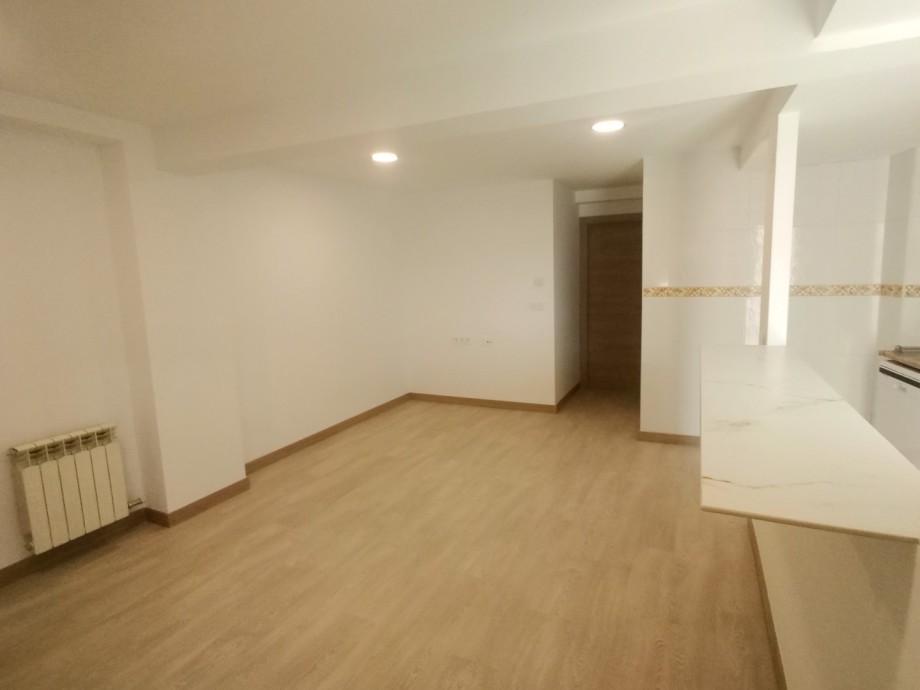 Salón reformado con barra de cocina en mármol