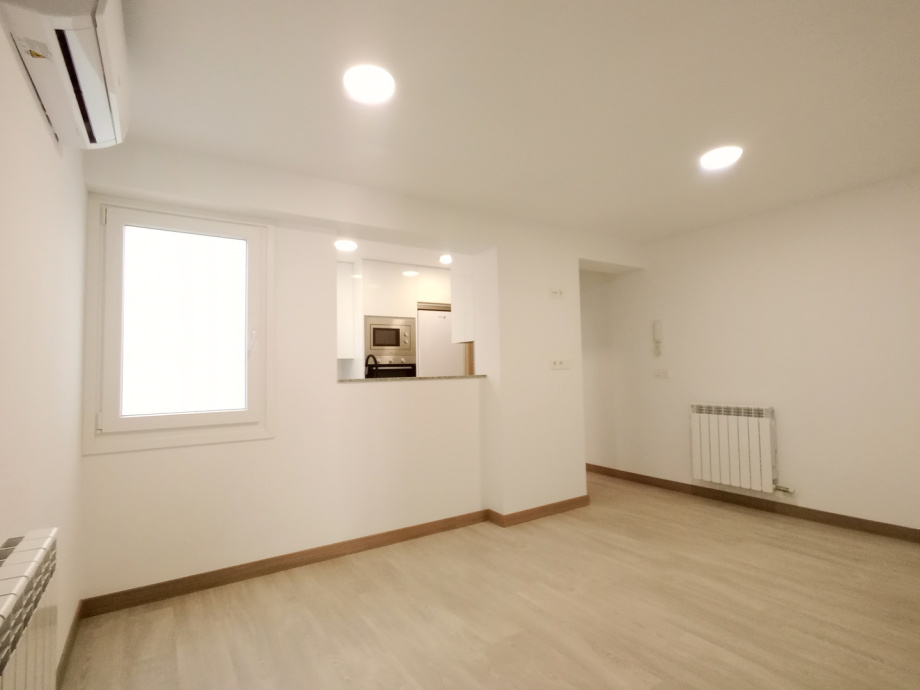 Salón con cocina abierta reformado en Zaragoza